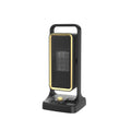 Black portable PTC ceramic desktop fan heater on a wooden desk.