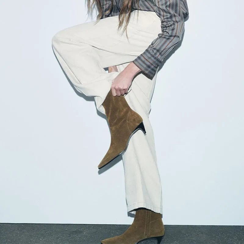 Brown square toe kitten heel mid-calf boots with side zipper on a wooden floor.