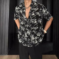 Man's loose black short sleeve shirt with a white floral print pattern.