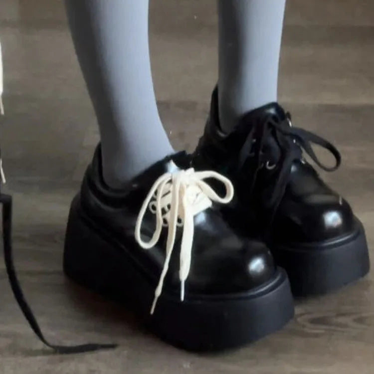 Matte black women's lace-up ankle boots with a chunky heel and buckle strap.