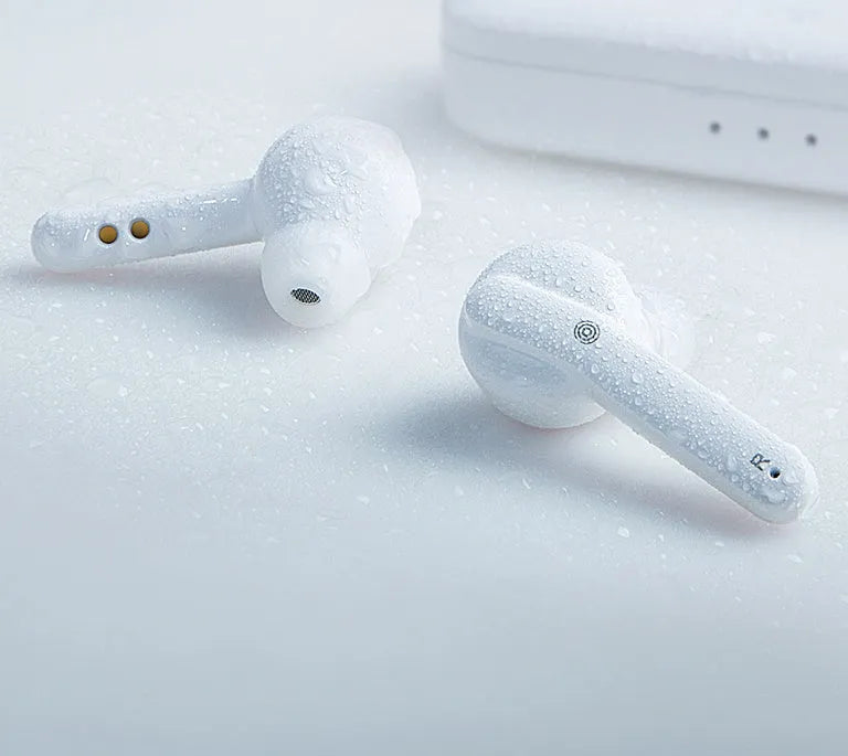 Black and white true wireless earbuds with charging case on a table, showing compact design.