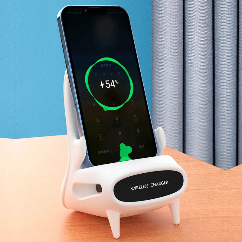White mini chair shaped wireless charging stand holding a mobile phone on a desk.