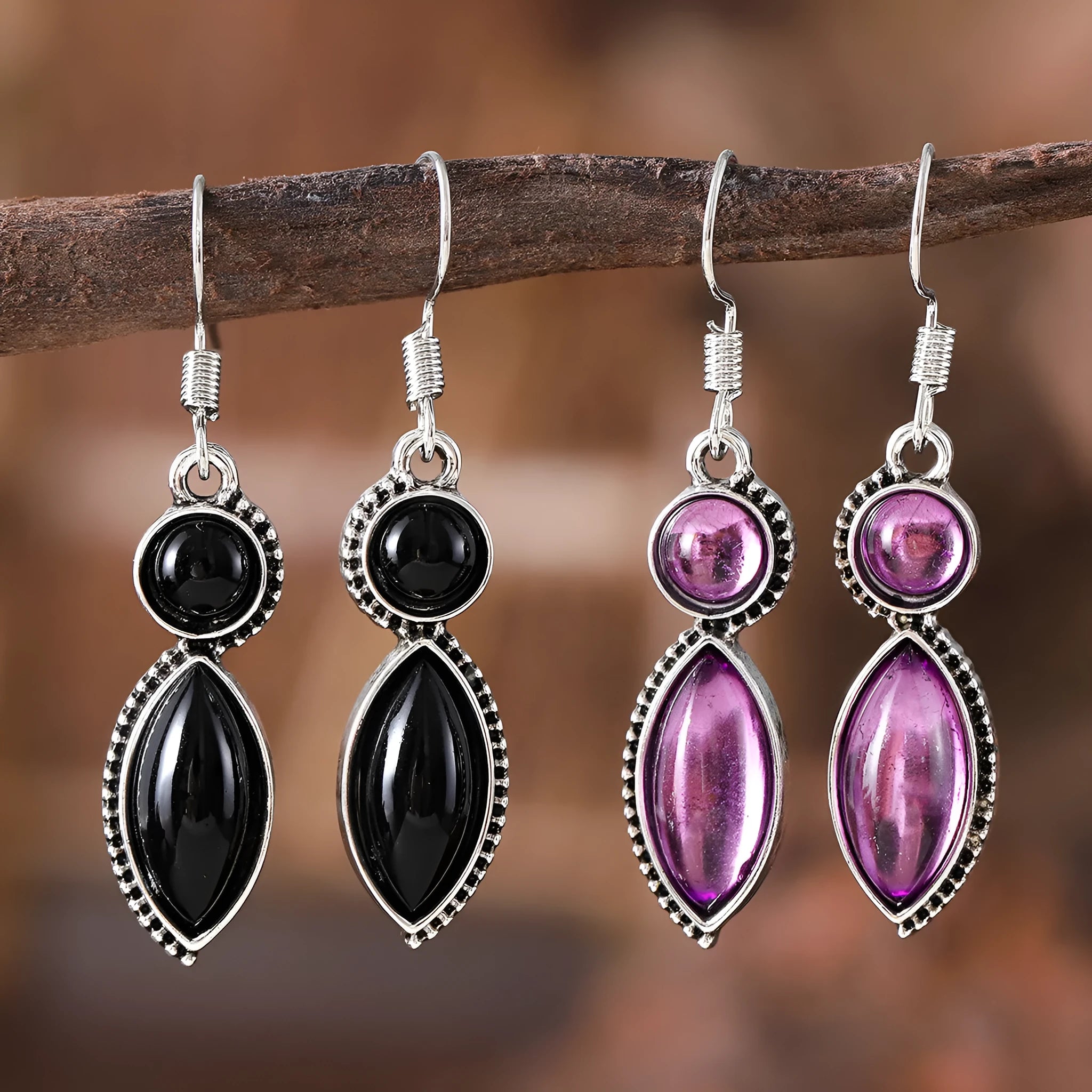 Close-up of vintage geometric drop earrings with black and purple electroplated finish and round details.