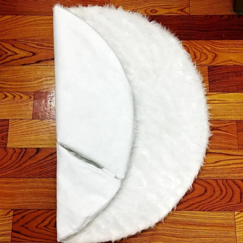 White plush Christmas tree skirt placed around base of decorated Christmas tree, 122cm size