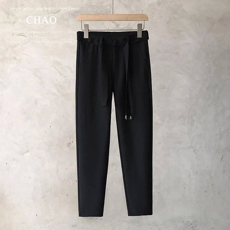 Boys slim straight wool trousers in tapered fit, shown in black, on a hanger.