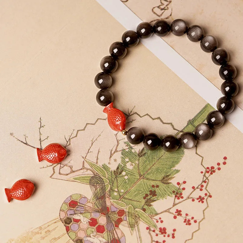 Natural obsidian bracelet with round cinnabar beads in three size options on a wrist
