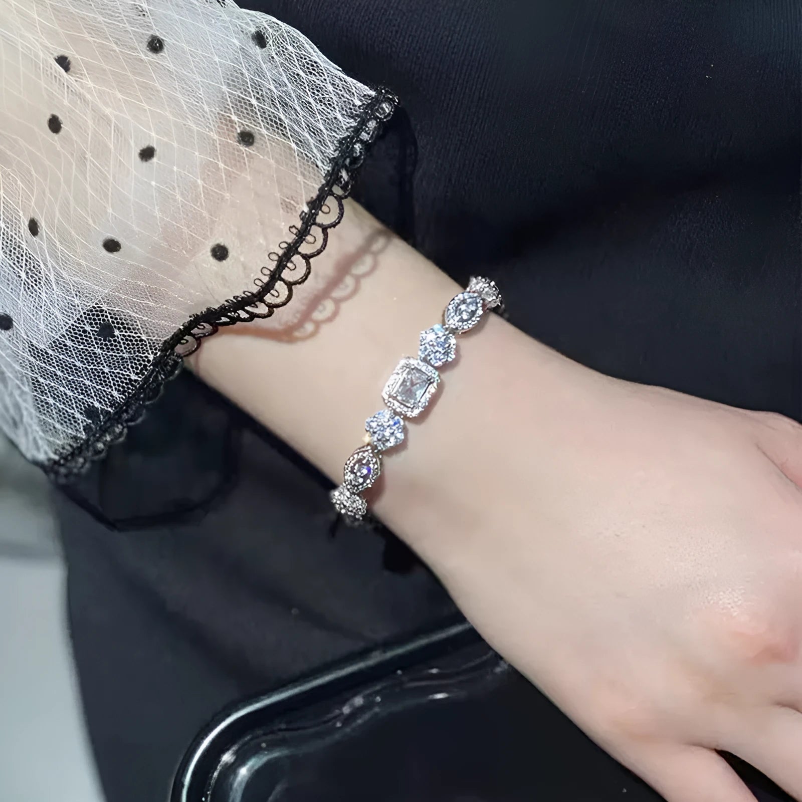 Women's geometric silver bracelet with adjustable chain and sparkling zircon stone on a wrist.