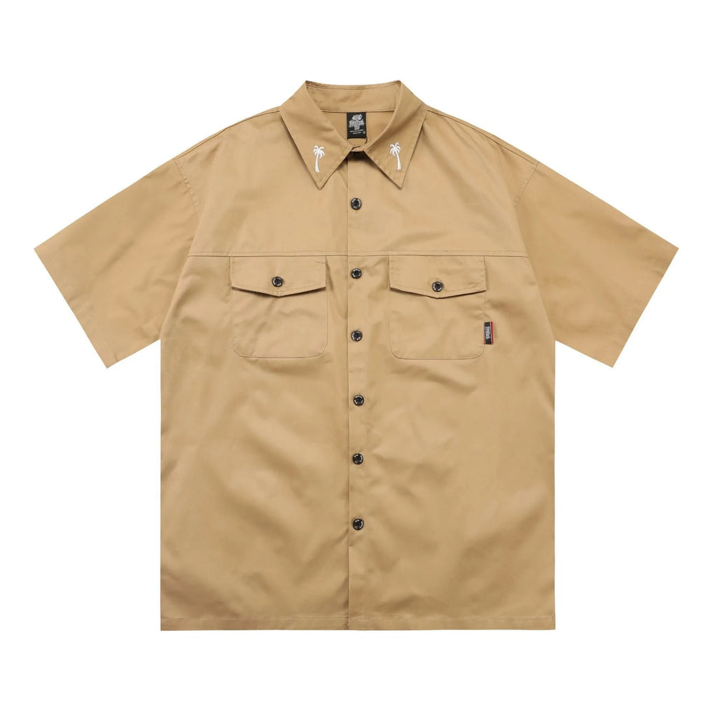 Man's black loose-fit pocket shirt with embroidery and half sleeves on a hanger.