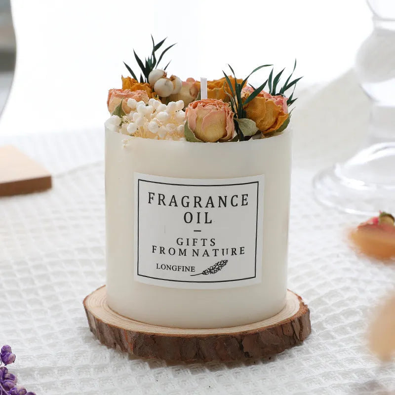 Decorative aromatherapy candle with dried flowers on a wood chip base, available in multiple scents.