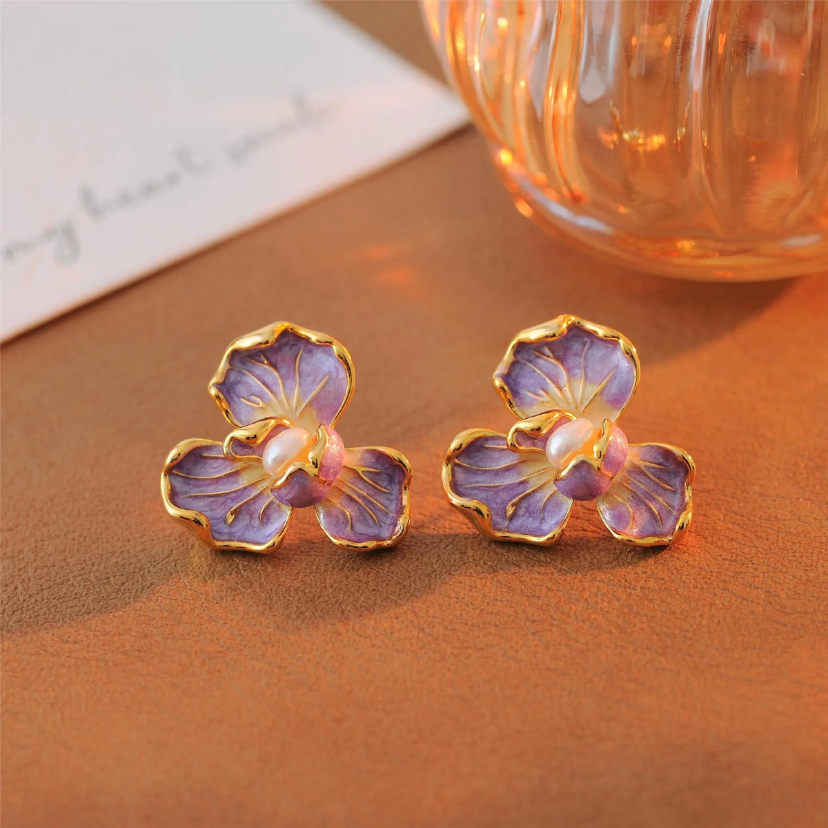 Purple copper alloy flower-shaped women's earrings with dripping oil finish on a plain background