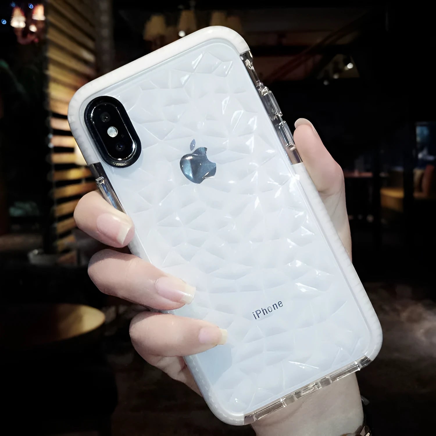 Striped pink and white TPU back cover case for iPhone on a table.