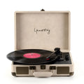 Portable Bluetooth record player in a leather-textured suitcase case, shown in a selection of colours.