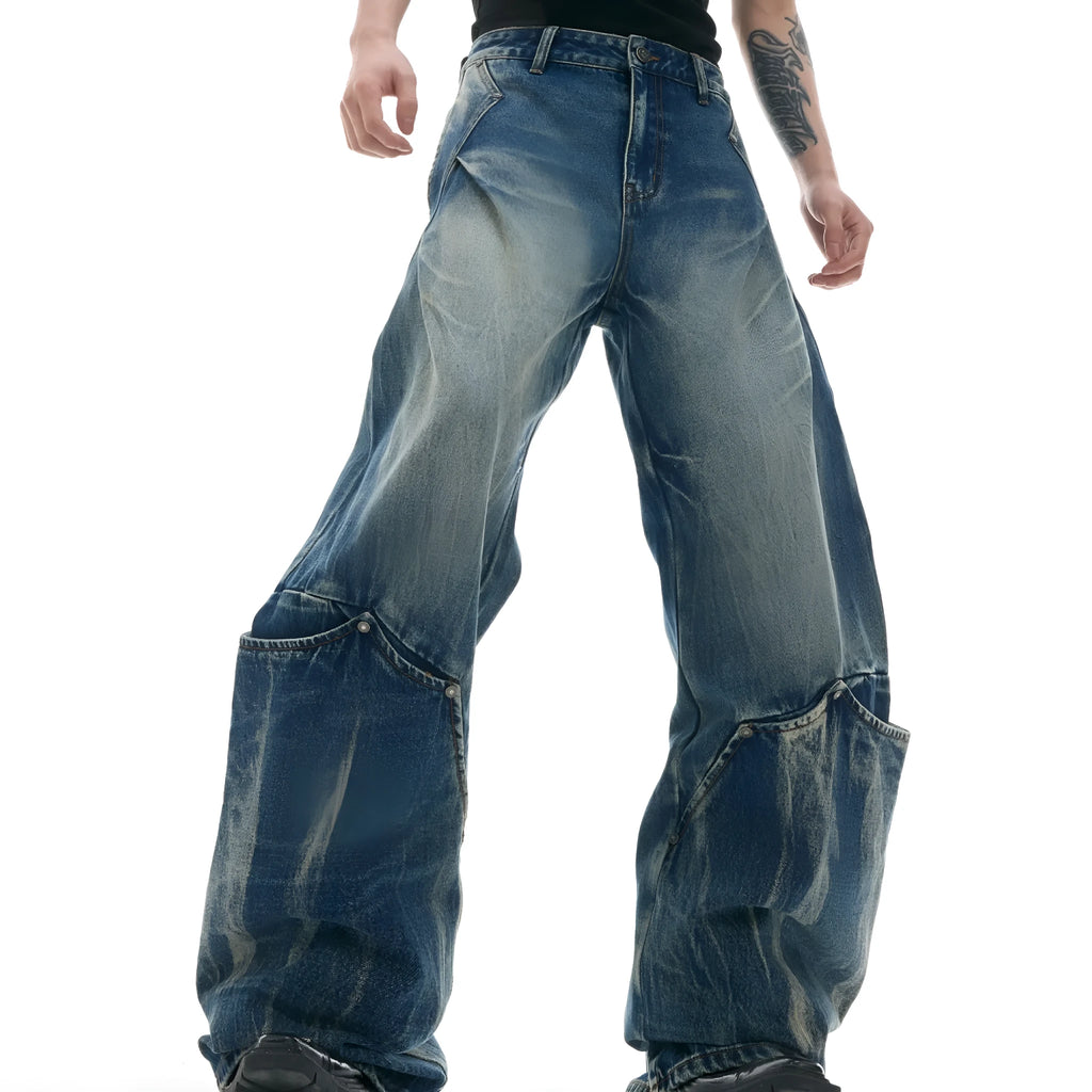 Man wearing verdant blue loose-fit jeans with a burst pattern wash and curved knife cut, front and side view.