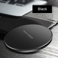 Black square wireless charging pad on desk with smartphone charging wirelessly