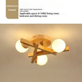Modern Nordic-style ceiling light with wooden accents and three white lamp heads mounted on a clean, white ceiling.