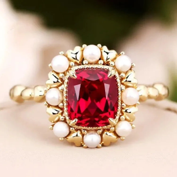 Gold electroplated ring with garnet red heart stone and geometric zircon setting.