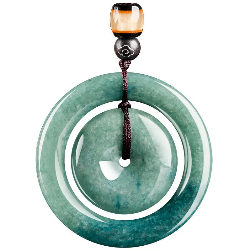 Emerald green jade pendant with carved national style design on a necklace stand