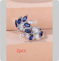 Adjustable copper leaf fashion ring with a blue zircon stone on a model's hand.