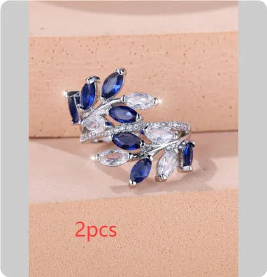 Adjustable copper leaf fashion ring with a blue zircon stone on a model's hand.