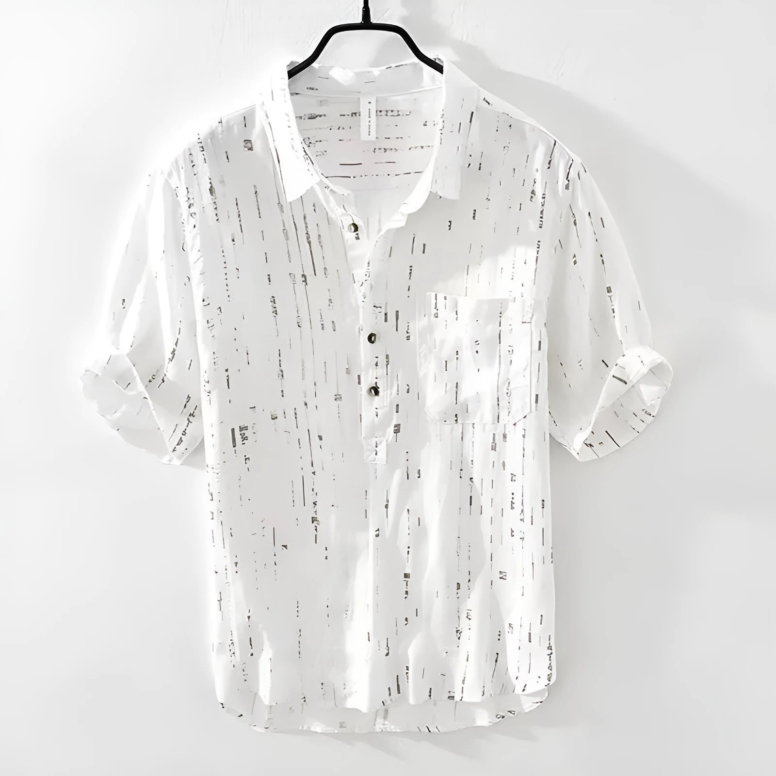 Mens loose-fit black polo shirt with a short sleeve and a V-neck lapel collar on a hanger.