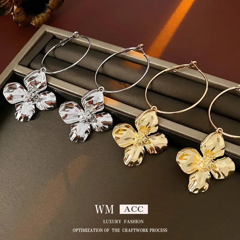 A pair of vintage-style geometric flower earrings with silver needle detailing, shown in gold and silver colour options.