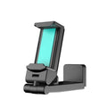 Foldable rotating universal phone holder in black on a desk next to a mobile phone.