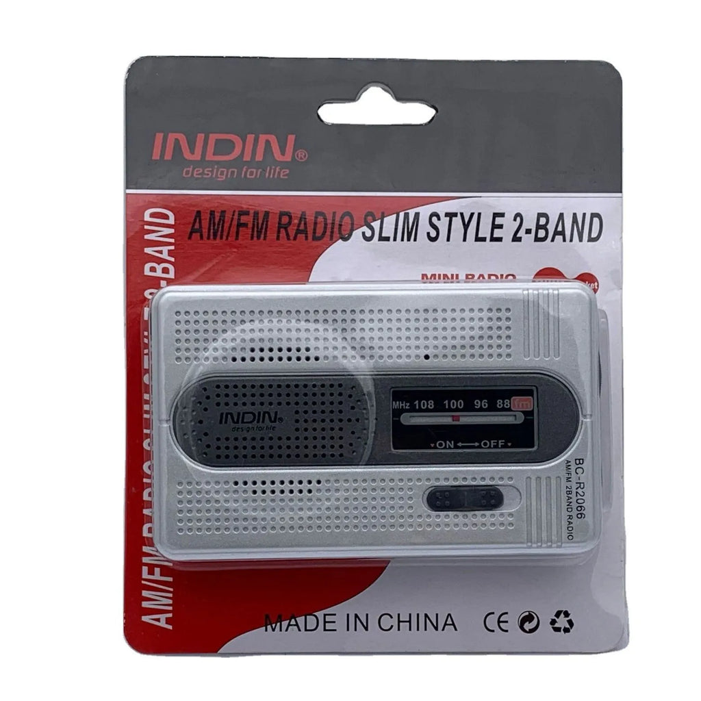Portable silver grey FM AM radio on table, compact ABS body with built-in speaker and dial controls