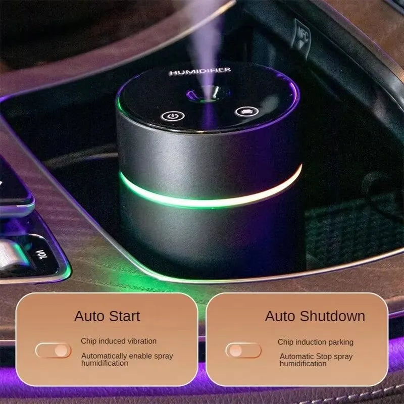 Black aluminium portable car humidifier and essential oil diffuser with USB cable on a desk.