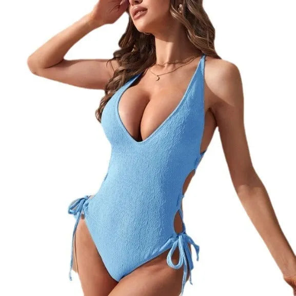 Women's black hollow backless one-piece swimsuit with sleeveless design and neck tether on a mannequin.