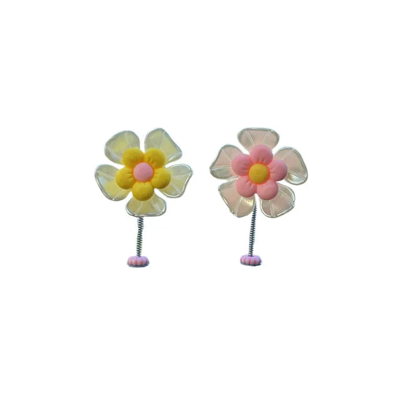 Small colourful plastic swing ornament for car dashboard, shown in multiple colour options.