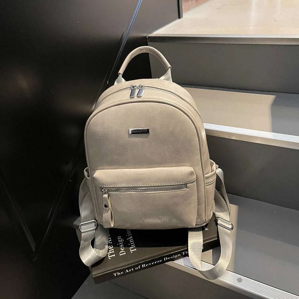 Simple fashion trendy ladies travel backpack in waterproof PU with sandwich pocket, available in multiple colours