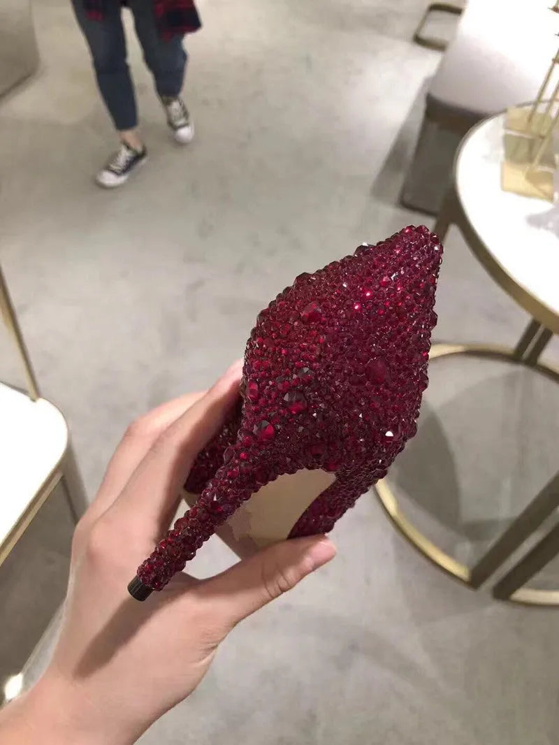 Gold women's stiletto high heels with rhinestone decoration and a pointed toe.