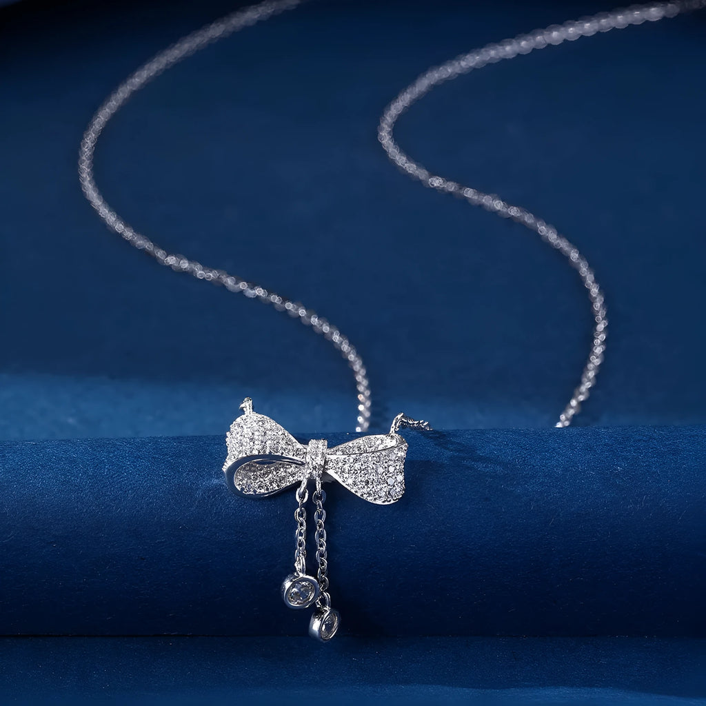 S925 sterling silver bow necklace on collarbone, showing O-ring chain and detailed bow pendant