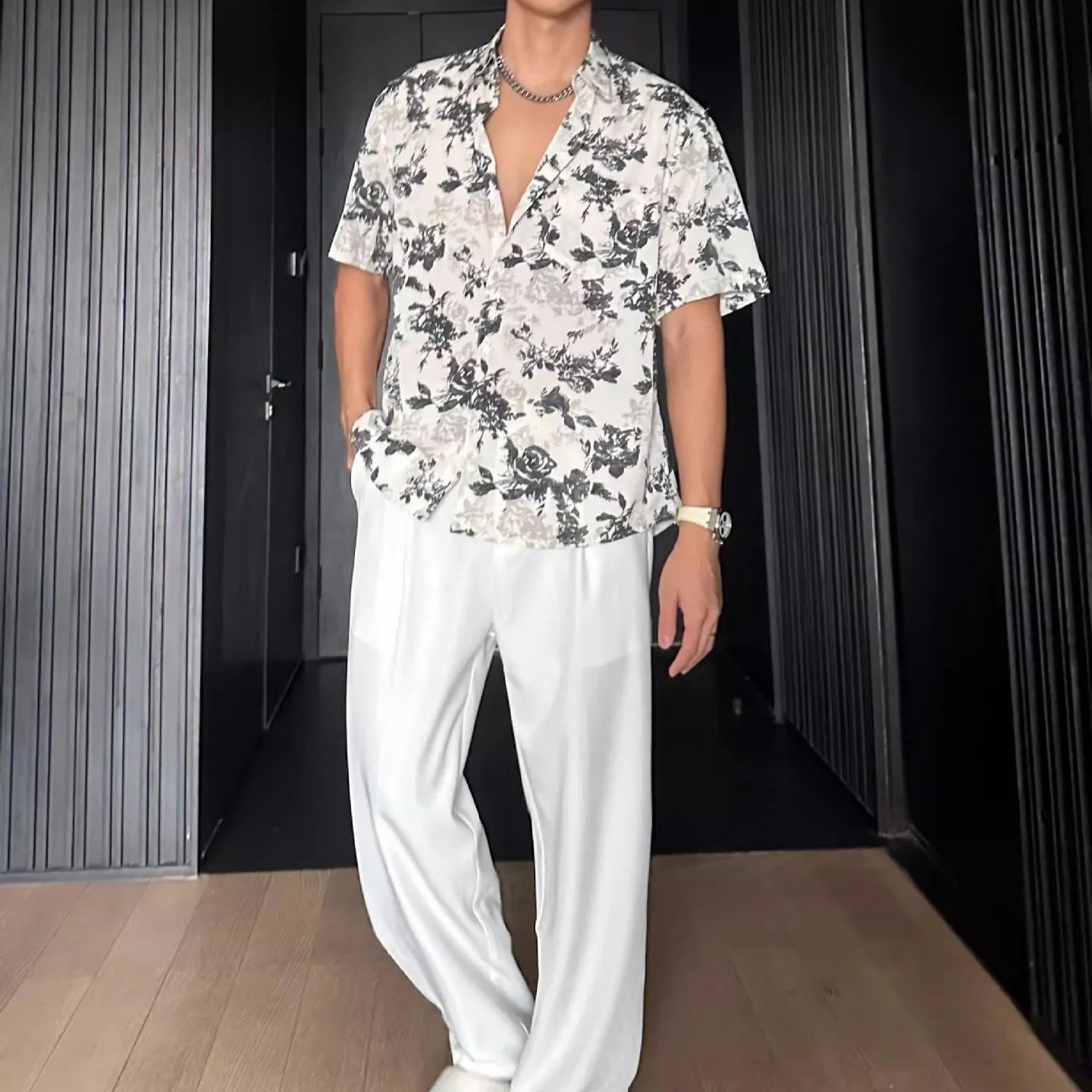 Man's loose black short sleeve shirt with a white floral print pattern.