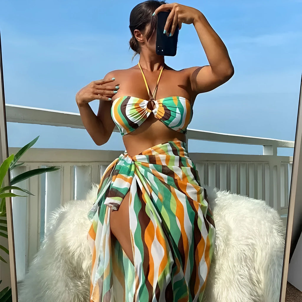 Women's yellow green printed bikini top and briefs with matching beach skirt laid flat.