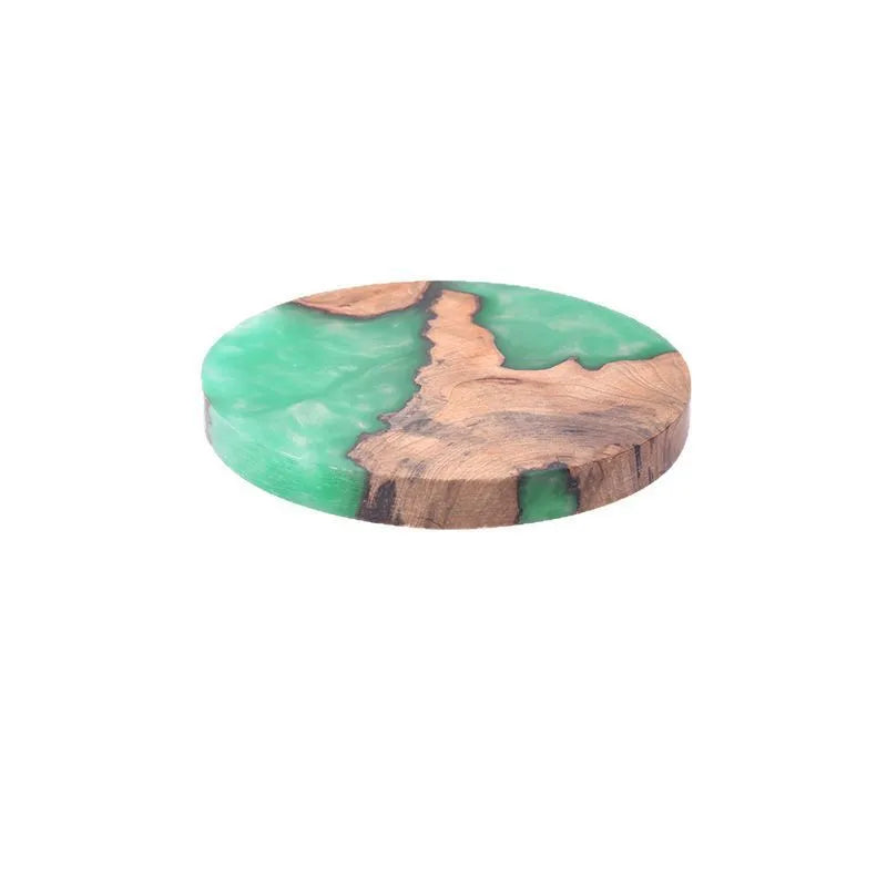 Set of solid wood coasters for tea, showing round green and black versions on a wooden table.