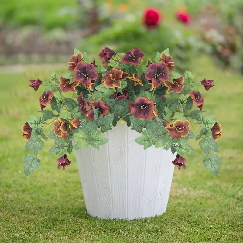 Purple plastic garden container with 12 forks holding red artificial silk flowers on a patio.