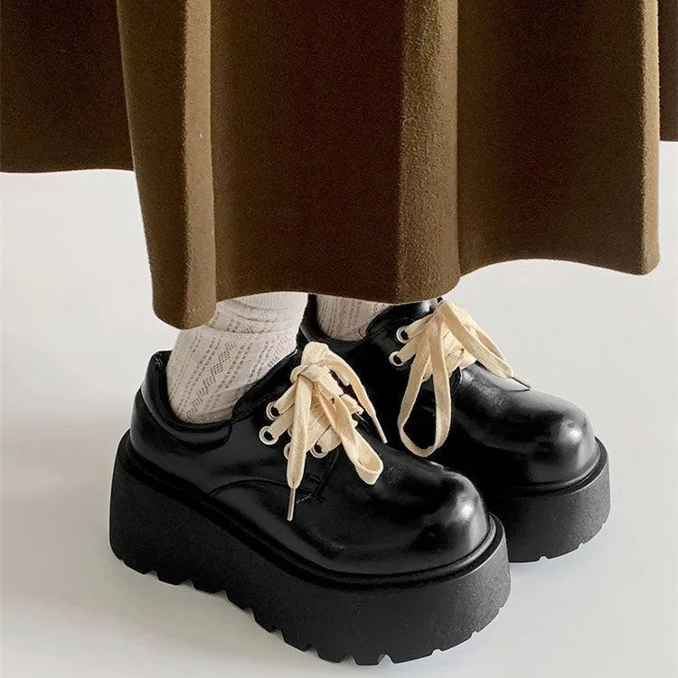 Matte black women's chunky sole lace-up shoes with a round toe and buckle detail.