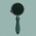 Green and pink double sided cat grooming brush with release button and flea comb on a white background.