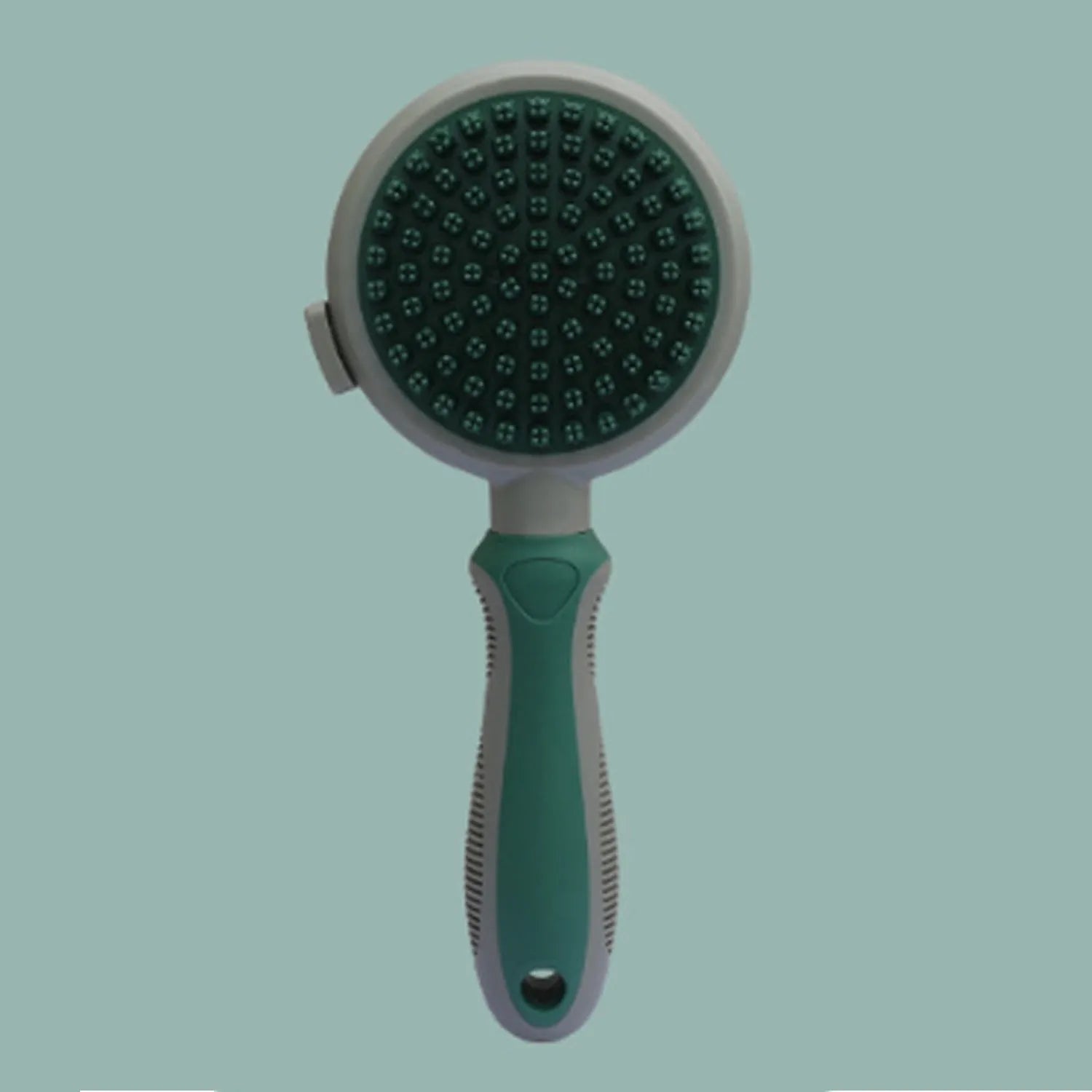 Green and pink double sided cat grooming brush with release button and flea comb on a white background.