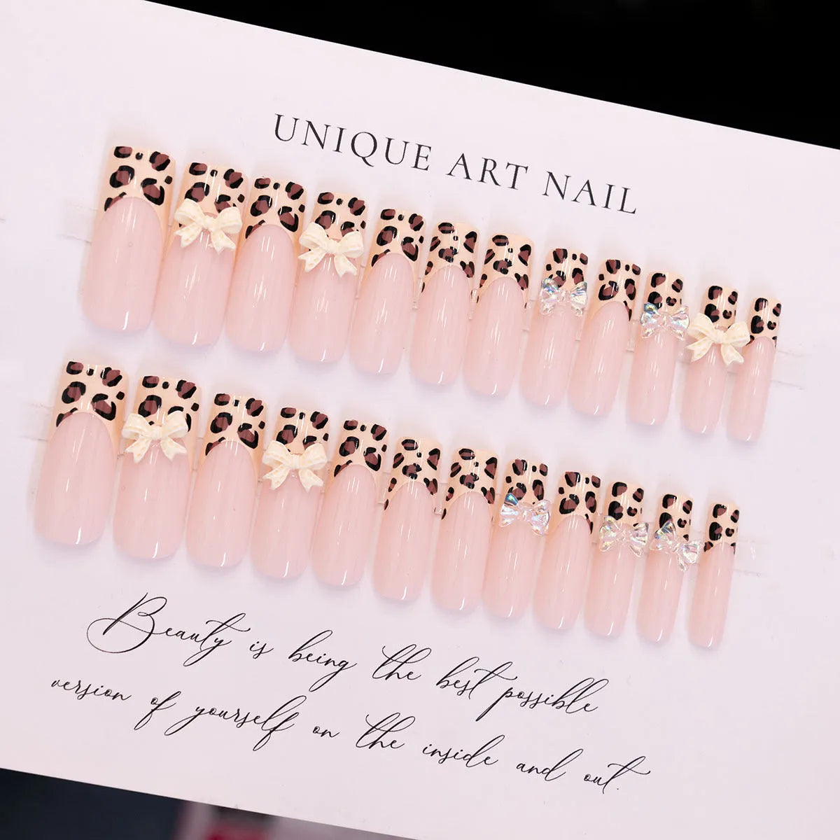 Leopard print pattern false nails with butterfly charms from a plastic nail art kit.