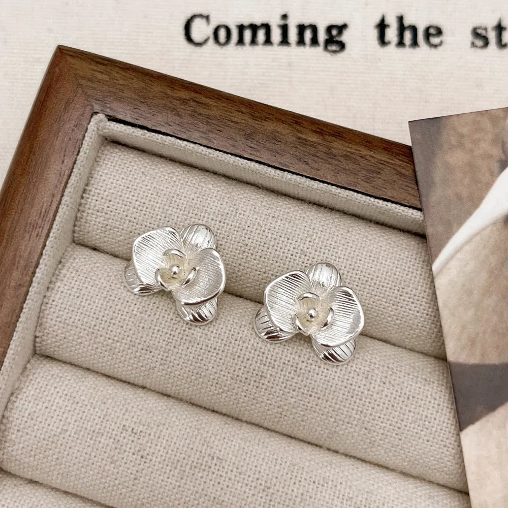 Women's retro flower earrings in copper with gold or silver electroplated finish showing petal detailing