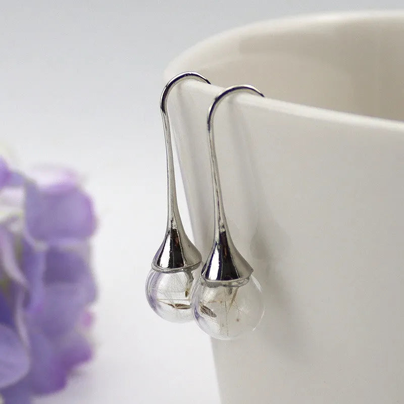 Clear glass ball earring with crystal dandelion seed inside on a silver French hook, 16mm size.