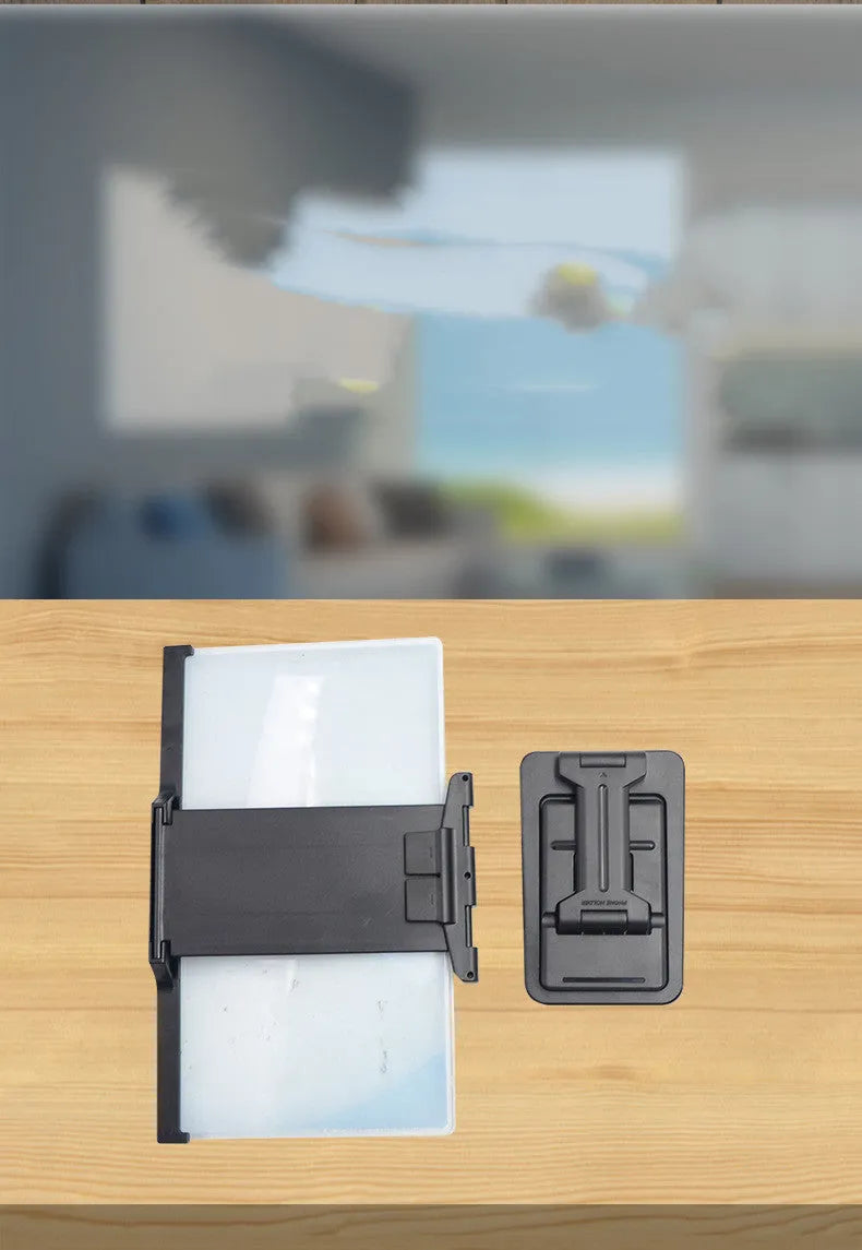 Black folding mobile phone screen magnifier and adjustable holder on a desktop.