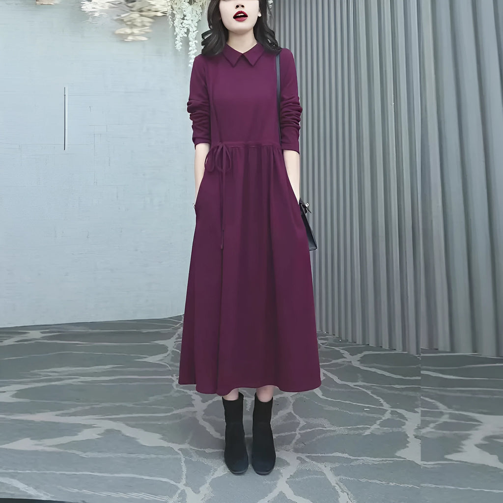 A purplish-red plus size winter dress with long sleeves and a long, flowing skirt, laid flat.