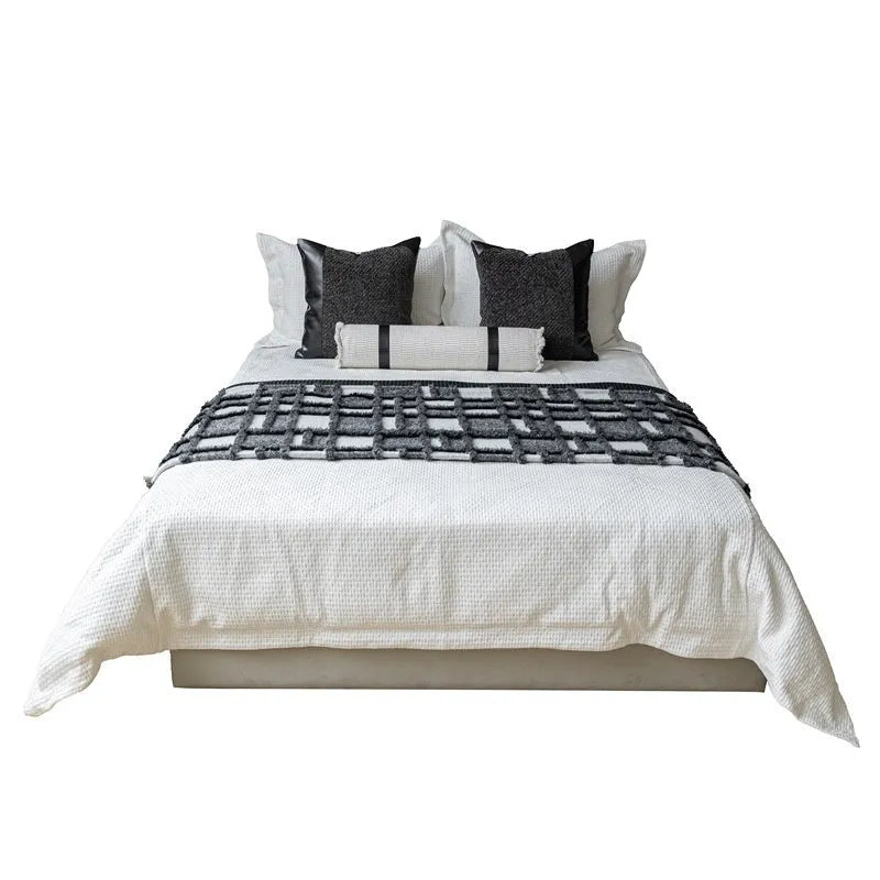 Modern grey and white plaid bed runner blanket and pillow set arranged on a double bed