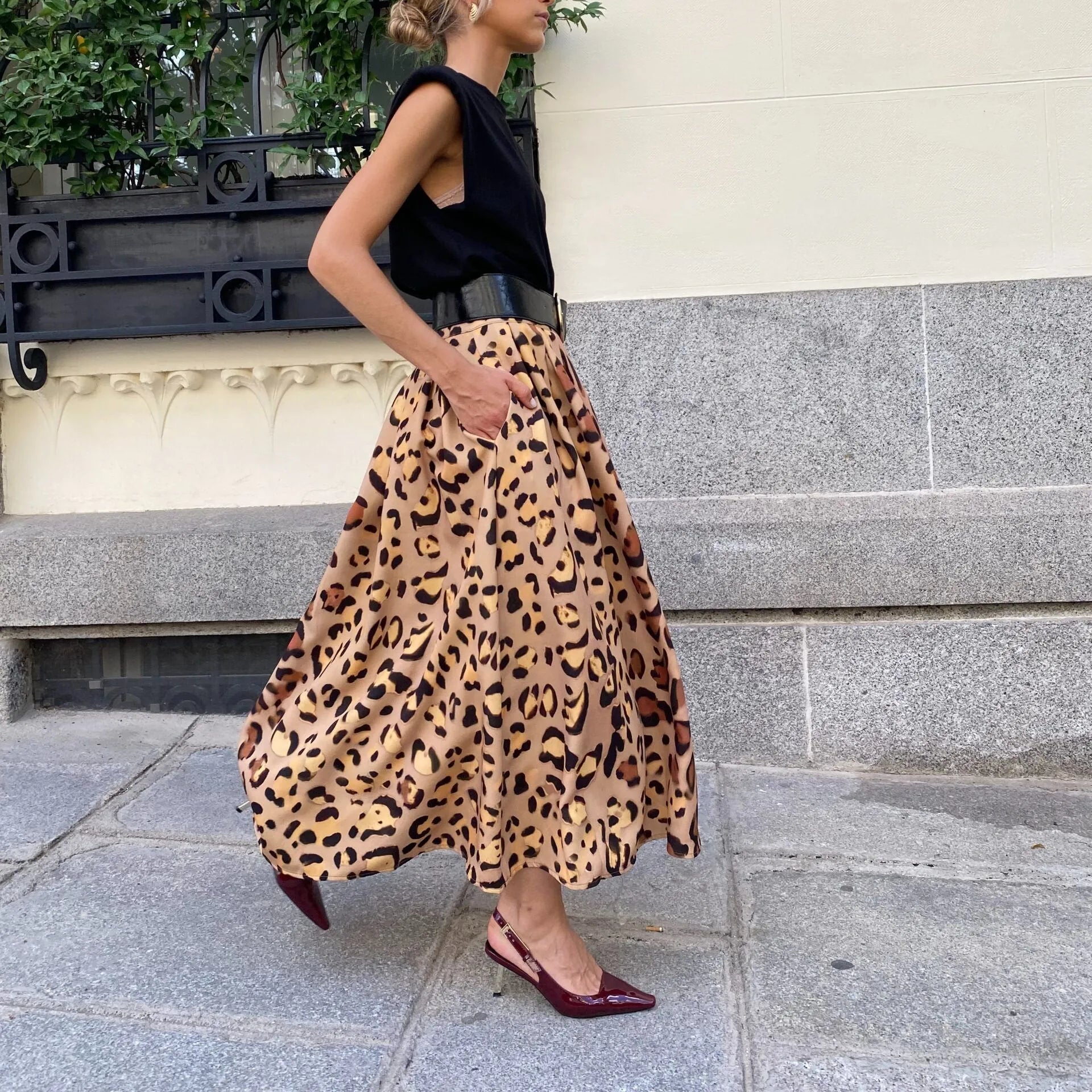 Brown leopard print women's A-line long skirt with a deep, flowing hem on a hanger.