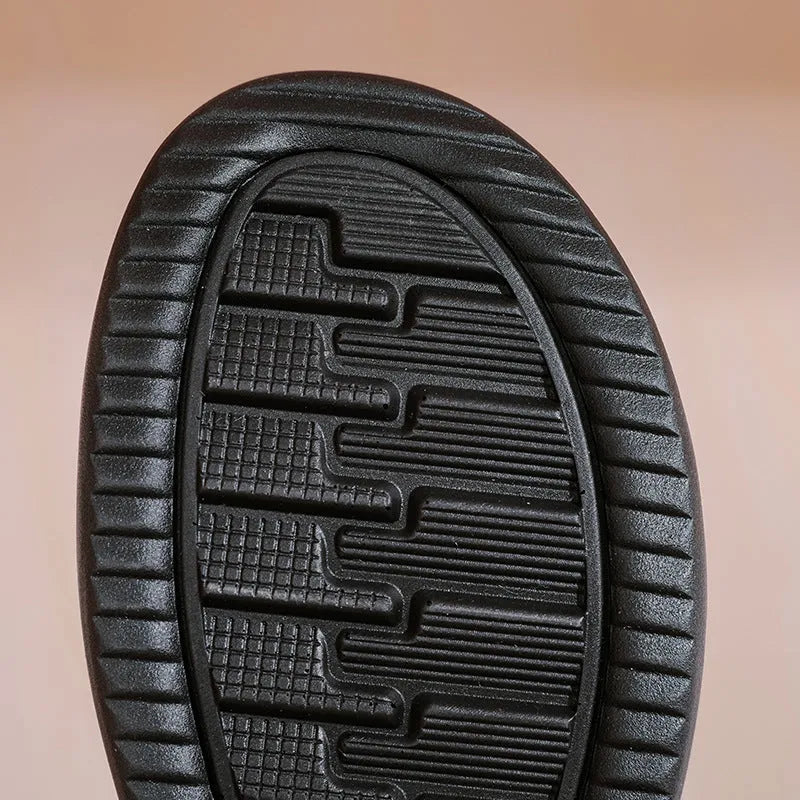 Pair of black cowhide ankle boots with side zipper, platform mid heel, and wool fleece lining visible at the top.