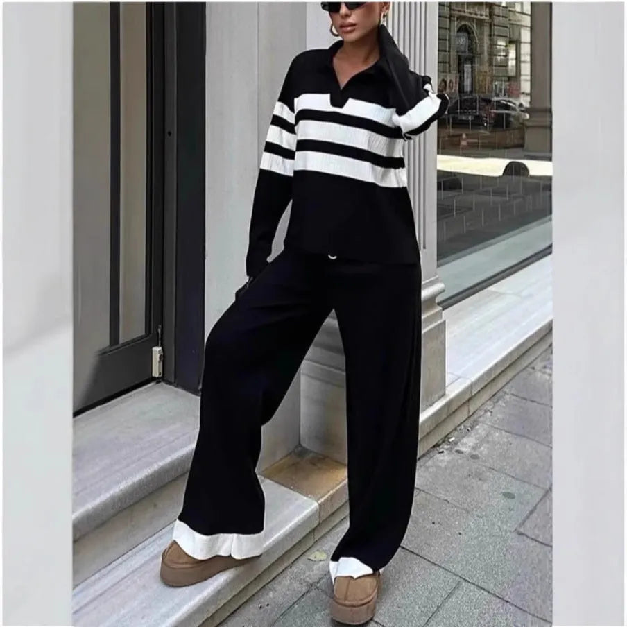 Women's black and white striped knitted polo shirt with long sleeves paired with matching trousers.