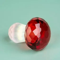 Small decorative crystal mushroom ornament in modern geometric style on a plain background.